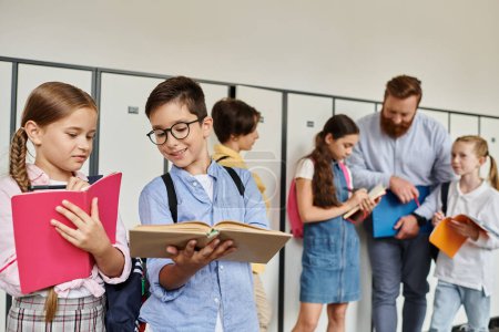 Photo for A man teacher is instructing a diverse group of school children standing in a bright hallway, engaging in lively interactions and learning moments. - Royalty Free Image