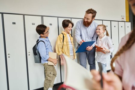 A male teacher instructs a diverse group of kids in a bright, lively classroom setting, with lockers in the background.
