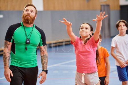 Photo for Kids and teacher in school gym, playing basketball - Royalty Free Image