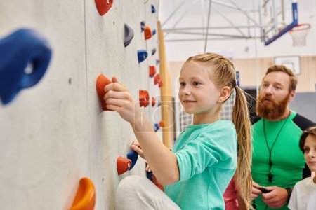 maestro y niños, reunidos alrededor de un colorido muro de escalada, participando en la escalada y recibiendo instrucciones