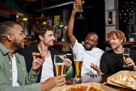 glücklich afrikanisch-amerikanischer Mann hebt Glas Bier in der Nähe von interrassischen Freunden während Junggesellenabschied