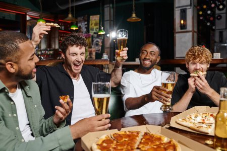 aufgeregter Mann hält Pizza und Bier in der Hand und schreit in der Nähe von interrassischen Freunden in einer Bar, Männerfreundschaft