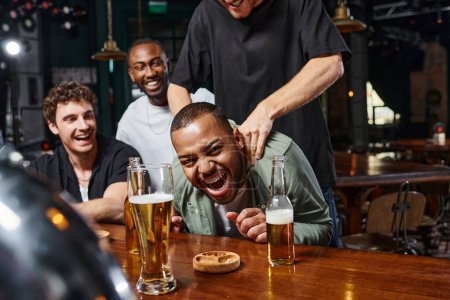 man touching shoulders of excited african american groom during bachelor party, male friendship