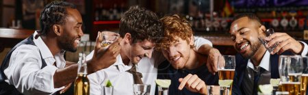 happy and drunk multiethnic friends hugging during bachelor party in bar, alcohol drinks banner