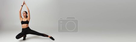 Foto de Joven deportista en ropa de gimnasio negro haciendo embestidas con las manos por encima de la cabeza sobre fondo gris, pancarta - Imagen libre de derechos