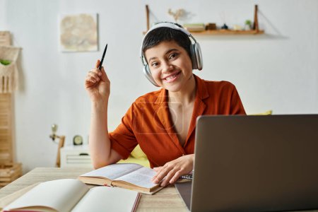 cheerful young female student with headphones and piercing smiling at camera, education at home