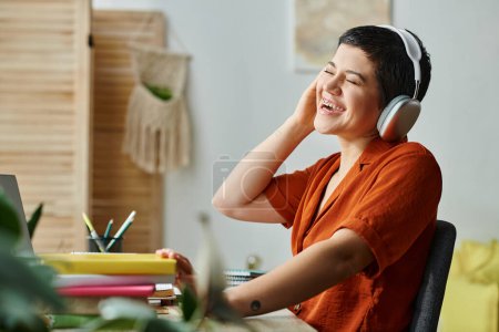 freudige Frau mit Kopfhörern und durchdringendem Lachen während des Fernunterrichts, Ausbildung zu Hause