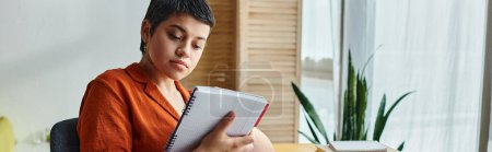 Photo for Hard working female student in homewear looking attentively at her notes, education at home, banner - Royalty Free Image