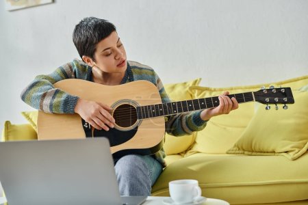 concentrated attractive woman learning how to play guitar on remote lesson, education at home