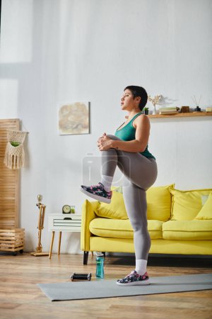 Foto de Tiro vertical de mujer atractiva joven con pelo corto en ropa deportiva ejercicio activo, aptitud - Imagen libre de derechos