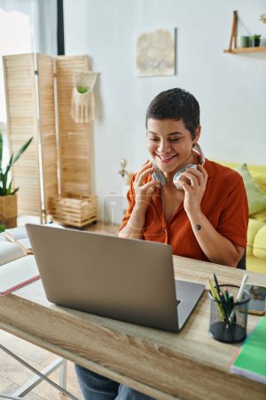 Photo for Vertical shot of cheerful student in front of laptop attending online classes, education at home - Royalty Free Image