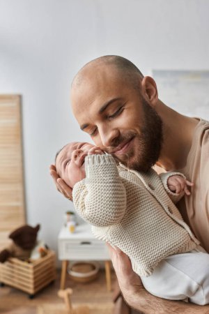 tiro vertical de padre cariñoso barbudo abrazando calurosamente a su bebé recién nacido, concepto de familia