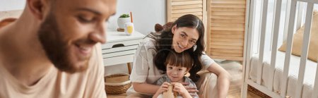 Photo for Focus on beautiful mother playing with little son and smiling at her blurred bearded husband, banner - Royalty Free Image