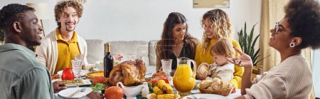 glückliche multirassische Familie und Freunde, die beim Thanksgiving-Dinner reden und lächeln, festliches Banner