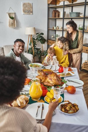 Thanksgiving celebration concept, interracial friends having festive dinner with lgbt couple