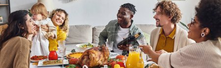 banner, african american man pouring wine into glass, multiracial family celebrating Thanksgiving