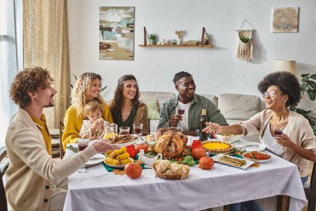 glücklicher Mann reicht Teller mit Bratkartoffeln an afrikanisch-amerikanische Frau beim Thanksgiving-Dinner