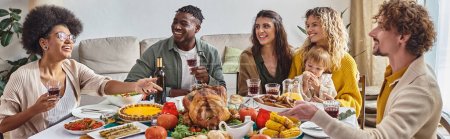 happy man passing plate with roasted potatoes to african american woman during Thanksgiving, banner