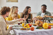 joyous interracial family and friends gathering at Thanksgiving table with various meals and drinks Mouse Pad 678866948