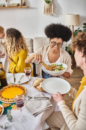 cheerful family enjoying delicious dinner while gathering on Thanksgiving, roasted turkey on table