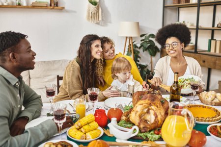 Group of multicultural friends or family members celebrating Thanksgiving together, roasted turkey