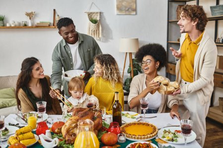 Fiesta de Acción de Gracias, felices amigos multiétnicos y reunión familiar en la mesa festiva con pavo