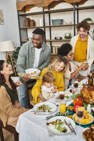 festive occasions, happy multiethnic family and friends gathering near turkey on Thanksgiving