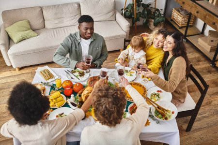 Joyeux Thanksgiving, souriants amis multiethniques et famille cliquetis verres de vin, vue sur le dessus