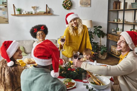 Téléchargez les photos : Joyeux Noël, amis multiculturels heureux et verres d'acclamation en famille près du dîner - en image libre de droit