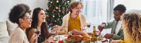 grande famille multiethnique souriant et mangeant un déjeuner festif avec arbre de Noël sur fond, bannière