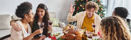 joyous multiethnic family sitting at holiday table enjoying feast and talking actively, banner