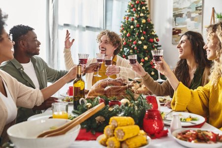 big happy interracial family gesturing and clinking wine glasses at holiday lunch, Christmas