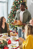 big multicultural family enjoying Christmas feast with wine and turkey and smiling sincerely Stickers #678871774