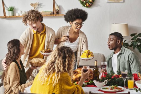cheerful young relatives enjoying celebration of Christmas together and smiling at each other