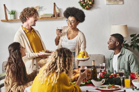 glückliche Familienmitglieder, die lächelnd am festlichen Tisch sitzen und miteinander reden, Weihnachten