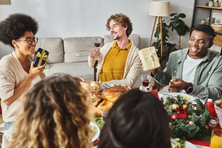 Téléchargez les photos : Heureux grande famille multiethnique passer du bon temps ensemble au déjeuner de vacances et boire du vin, Noël - en image libre de droit