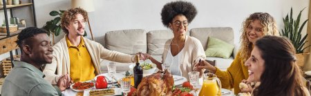 lächelnde multiethnische Familie sitzt und hält neugierige Hände am Festtagstisch, Thanksgiving, Banner