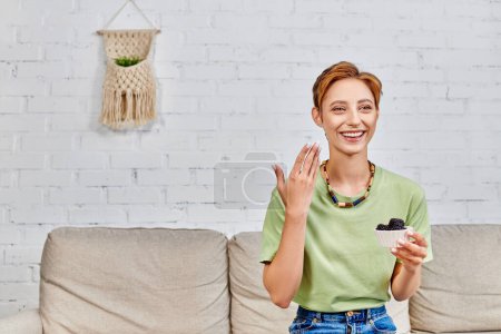 Téléchargez les photos : Femme heureuse avec bol de mûres fraîches pointant vers son visage parfait sain, concept végétarien - en image libre de droit