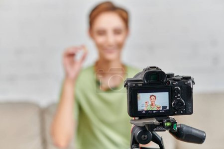 Téléchargez les photos : Focus sur appareil photo numérique devant une femme végétarienne heureuse avec de la nourriture à base de plantes, création de contenu - en image libre de droit