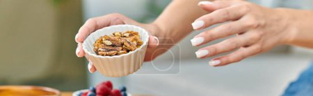 Téléchargez les photos : Vue recadrée d'une femme végétarienne tenant un bol avec des noix, concept de régimes à base de plantes, bannière - en image libre de droit