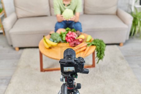 vista de ángulo alto de la cámara digital cerca de la mujer recortada con productos de origen vegetal durante el video blog