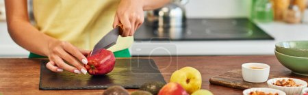 vista recortada de la mujer cortando manzana cerca de frutas maduras y varios ingredientes vegetarianos, pancarta