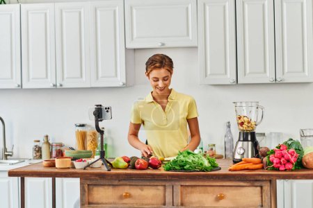kulinarisches Videoblog, Frau bereitet vegetarisches Essen aus Zutaten frischen pflanzlichen Ursprungs in der Küche zu