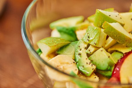 Nahsicht auf vegetarischen Salat mit frischem Obst und Honig mit Sesam, pflanzliche Kost
