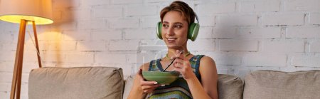 mujer feliz sentada con un tazón de comida vegetariana y escuchando música en auriculares, pancarta
