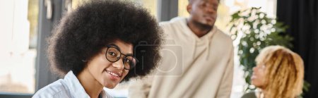 jeune femme avec des lunettes souriant à la caméra avec ses amis sur fond, bannière de processus de travail