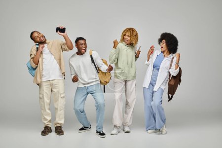 jolly cheering group of friends in casual wear gesturing and posing on gray background, students