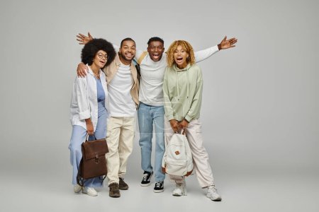 junge afrikanisch-amerikanische Freunde in Freizeitkleidung mit Rucksäcken, die fröhlich in die Kamera lächeln, Studenten