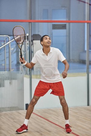 energetic african american sportsman playing squash inside of court, challenge and motivation
