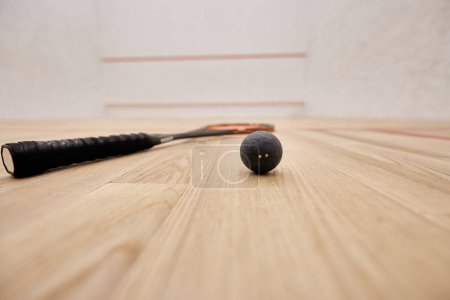 bola y raqueta dentro de la cancha de squash con paredes blancas, motivación y concepto de determinación
